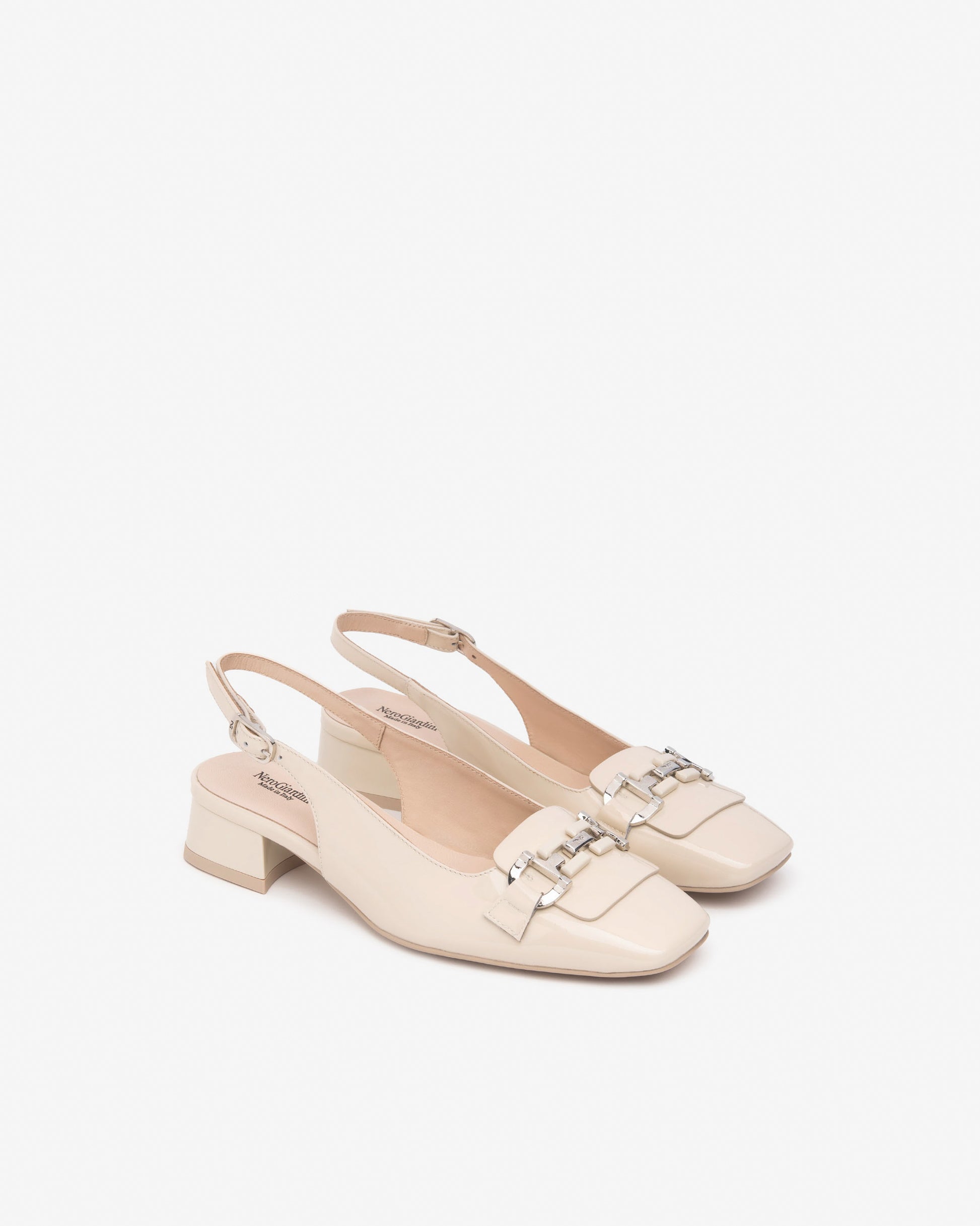 Diese stilvollen Slingback-Pumps von NeroGiardini in edlem Elfenbein bestehen aus hochwertigem Lackleder und vereinen klassisches Design mit moderner Bequemlichkeit. Der 3 cm hohe Blockabsatz und die Schnalle sorgen für sicheren Halt und angenehmen Komfort – perfekt für Büro, Events oder einen eleganten Stadtbummel. Ein zeitloser Schuh im italienischen Stil, der zu vielen Outfits passt.