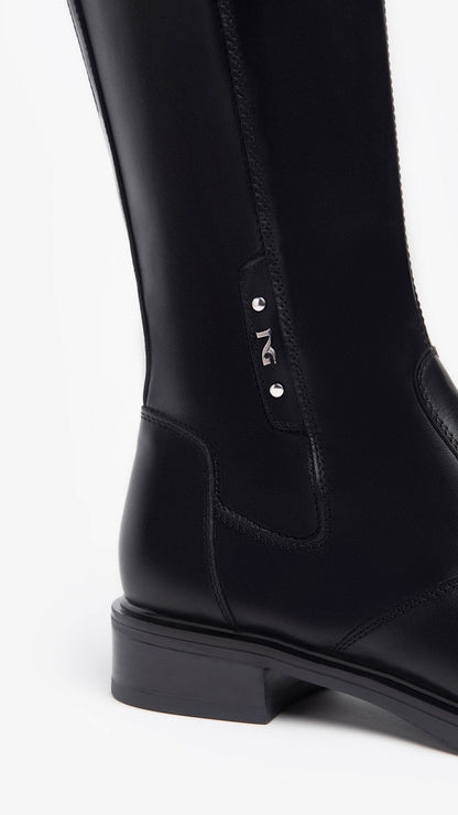 Der kniehohe Damenstiefel von NeroGiardini kombiniert italienische Handwerkskunst mit modernem Stil und Funktionalität. Gefertigt aus hochwertigem Leder in Kombination mit technischem Material sorgt er für optimalen Halt und Eleganz. Das Innenfutter aus Leder sowie die herausnehmbare DryGo!®-Innensohle garantieren maximalen Komfort und perfekte Atmungsaktivität. Der seitliche Reißverschluss erleichtert das Anziehen, während der stabile 5 cm Blockabsatz den femininen Look unterstreicht.