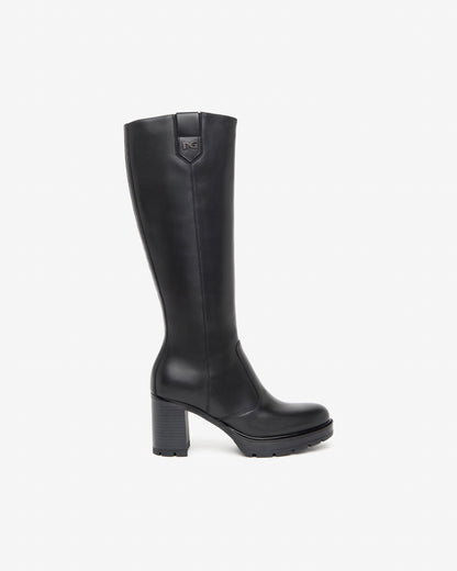 Der elegante Langschaftstiefel von NeroGiardini überzeugt durch seine schlichte Raffinesse und hochwertige Verarbeitung. Komplett aus feinstem Leder gefertigt, bietet er einen angenehmen Tragekomfort – auch bei längeren Tragezeiten. Der 8 cm hohe Blockabsatz streckt optisch das Bein und sorgt dennoch für sicheren Stand. Der praktische Reißverschluss an der Innenseite erleichtert das An- und Ausziehen. Perfekt für stilvolle Herbst- und Winteroutfits!