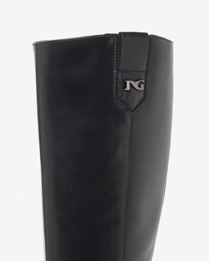 Der elegante Langschaftstiefel von NeroGiardini überzeugt durch seine schlichte Raffinesse und hochwertige Verarbeitung. Komplett aus feinstem Leder gefertigt, bietet er einen angenehmen Tragekomfort – auch bei längeren Tragezeiten. Der 8 cm hohe Blockabsatz streckt optisch das Bein und sorgt dennoch für sicheren Stand. Der praktische Reißverschluss an der Innenseite erleichtert das An- und Ausziehen. Perfekt für stilvolle Herbst- und Winteroutfits!